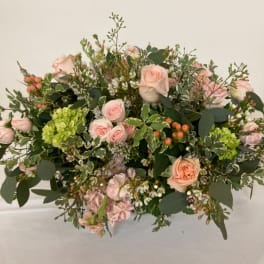 Blush roses and green hydrangeas in a low, lush bouquet