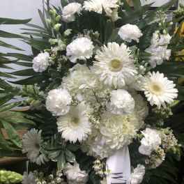 White sympathy spray with gerberas, carnations, and hydrangeas
