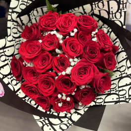 Bouquet of red roses with white filler in black-and-white wrap