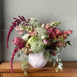 Mixed bouquet in a white vase with pink and white blooms