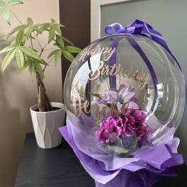 Purple birthday balloon with flowers and ribbon