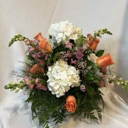 Bouquet of white hydrangeas and orange roses in a vase