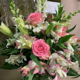 Pink roses and white lilies arranged with pink alstroemeria in a bouquet