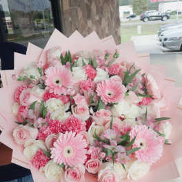 Pink and white bouquet with gerbera daisies and roses in pale pink wrap