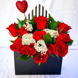 Red roses in a black gift box with a glittery heart pick