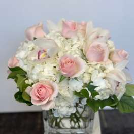 Pink roses and white hydrangeas in a clear glass vase