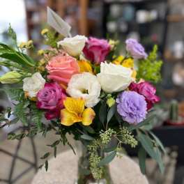 Mixed bouquet of roses, lisianthus, and alstroemeria in a glass vase