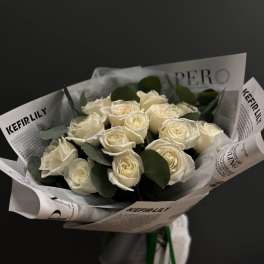 Bouquet of white roses wrapped in printed paper