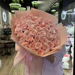 Large bouquet of pale pink roses wrapped in pink paper