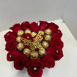 Heart-shaped bouquet of red roses with gold-wrapped chocolates and a butterfly topper