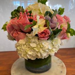 Pink roses and white hydrangeas arranged in a glass vase