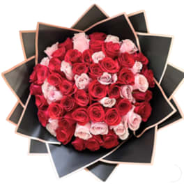 Bouquet of red and pink roses wrapped in black paper