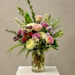 Mixed bouquet of pink and white flowers in a clear glass vase