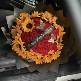 Red rose bouquet with orange sunflowers and a Happy Anniversary ribbon