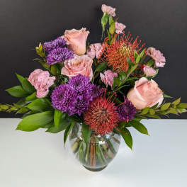 Pink and purple mixed bouquet in a glass vase