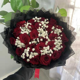 Bouquet of red roses with white baby's breath wrapped in black paper