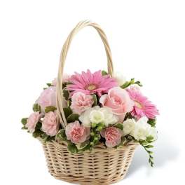 Pink and white flowers arranged in a wicker basket