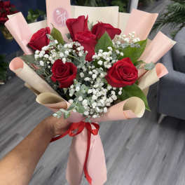 Bouquet of red roses with baby's breath in pink wrapping
