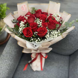 Bouquet of red roses with baby's breath in beige wrap