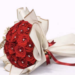 Bouquet of red roses wrapped in cream paper with a red ribbon