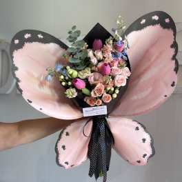 Pink and black butterfly-shaped bouquet with mixed flowers and ribbon