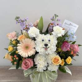 Flower arrangement shaped like a white teddy bear with roses and daisies