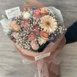 Bouquet of pink and peach roses with a pale gerbera daisy