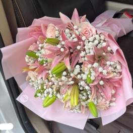 Pink lily and rose bouquet wrapped in pale pink paper