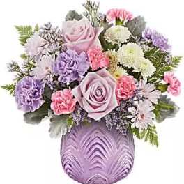 Lavender and pink flower arrangement in a purple vase