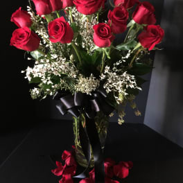 Bouquet of red roses in a glass vase with a black ribbon