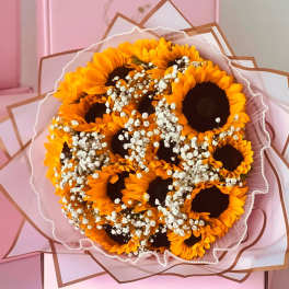 Bouquet of sunflowers with baby's breath in pink wrapping