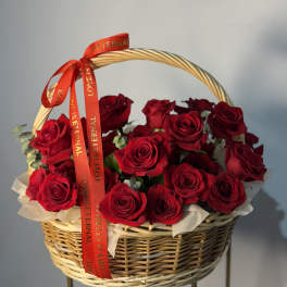 Basket of red roses with a red ribbon