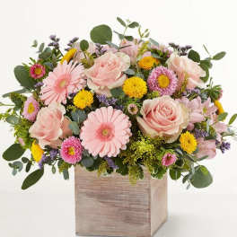 Pink roses and daisies arranged in a wooden box