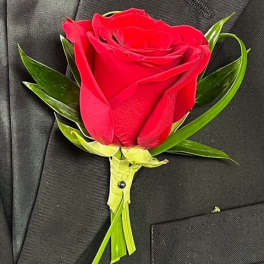 Red rose boutonniere pinned to a black suit jacket