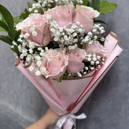 Pink roses with white baby's breath in pink wrapping