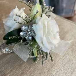 Small white rose corsage with rhinestone accents and sheer ribbon