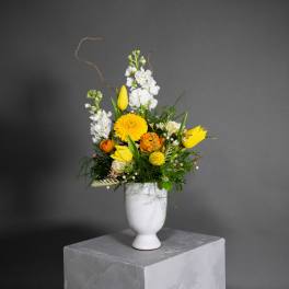 Yellow and white floral arrangement in a white vase