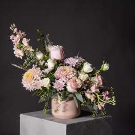 Pink and white floral arrangement in a blush vase