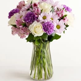 Bouquet of pink and purple flowers in a clear glass vase