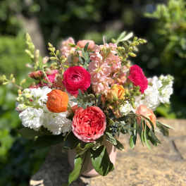 Mixed bouquet of pink, white, and orange flowers in a vase