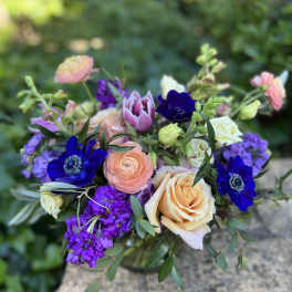 Bouquet of peach roses, purple blooms, and pink tulips