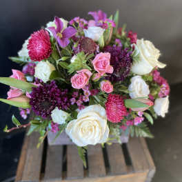 Mixed pink and white flower bouquet in a wooden crate