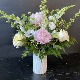 Pink and white floral arrangement in a ribbed white vase