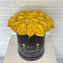 Yellow roses arranged in a black round box
