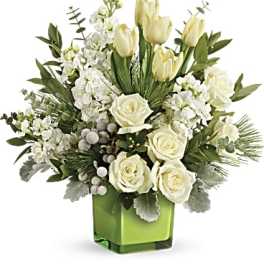 White roses and tulips in a green glass vase
