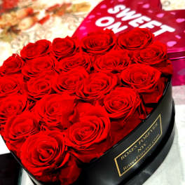 Heart-shaped box of red roses with a pink "Sweet On" lid