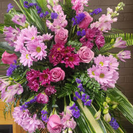 Large pink and purple floral standing spray with roses and daisies
