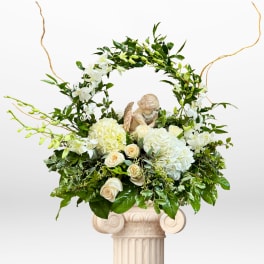 White floral arrangement with roses and hydrangeas on a pedestal