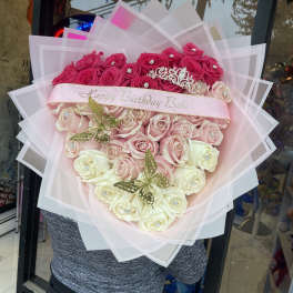 Heart-shaped bouquet of pink and white roses with a birthday ribbon