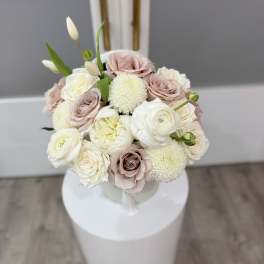 Bouquet of blush and white roses with round white blooms in a vase